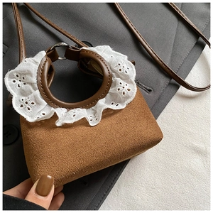 Gros plan du mini sac bourse en daim marron avec dentelle blanche et poignée ronde chic