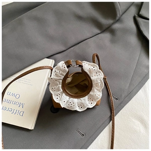 Détail d'un mini sac bandoulière en cuir marron avec broderie en dentelle blanche florale