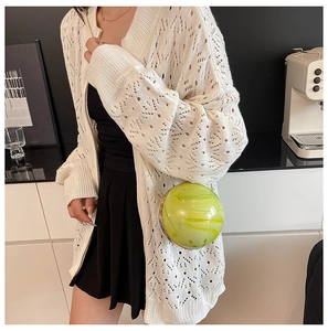 Dettaglio macro della borsa a sfera con texture marmo verde e catena dorata