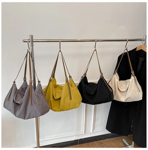 Detailed display of lightweight nylon tote bags in grey, yellow, black and beige colors