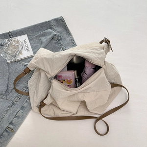 Overhead view of off-white wrinkled nylon tote bag showing spacious interior with brown straps