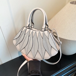 Detailansicht der cremeweißen Designer-Handtasche mit eleganter Naht und rundem Griff