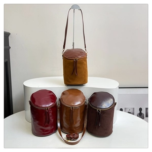 Detalle de bolsos bombonera retro en cuero y ante con cremallera doble de borlas