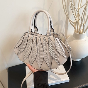 Detailansicht der beigefarbenen Handtasche in Fächerform mit blattartigem Nahtmuster