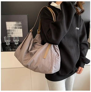 Detail of grey-purple nylon hobo tote bag with brown leather strap and adjustable buckle