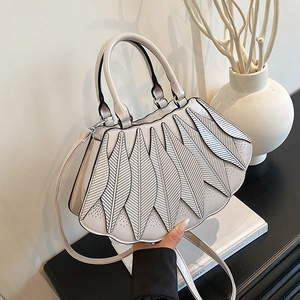 Detail des lasergeschnittenen Blattdesigns und der Textur der cremefarbenen Tasche