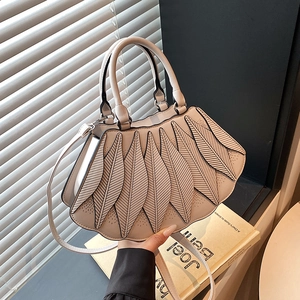 Detail einer beigen fächerförmigen Handtasche mit Blatt-Leder-Lagen und feinen Nähten