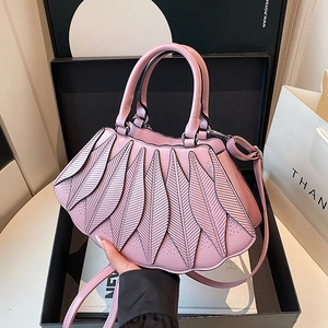 Detail einer hellrosa Handtasche mit Blattfalten-Design und feiner Laserperforation