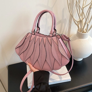 Detail der rosa Handtasche mit künstlerischer fächerförmiger Blattstruktur und Gravur