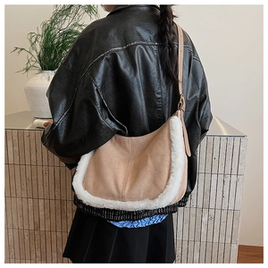 Detail of hobo bag featuring beige suede material and white faux fur trim on the edges