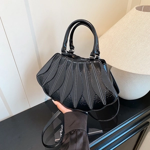 Detailansicht der schwarzen Ledertasche mit weißen Radialstreifen und Laser-Cut-Muster