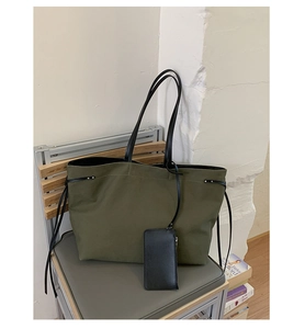 Dettaglio della borsa tote in tela verde militare con coulisse, lacci neri e mini pochette