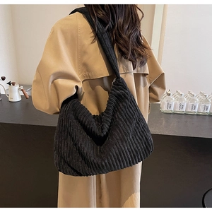 Close-up of black corduroy tote bag showing its textured fabric and slouchy hobo style