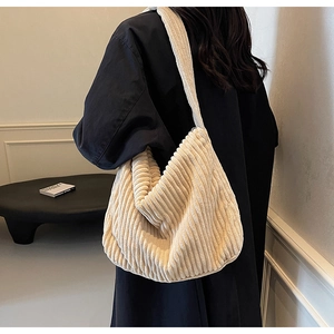 Close-up of off-white corduroy tote bag showing ribbed texture and wide shoulder strap