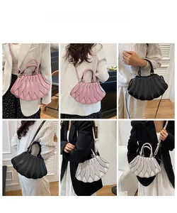 Modellpräsentation der plissierten Handtasche in Muschelform in verschiedenen Tragevarianten