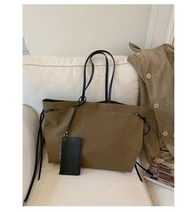 Dettaglio della borsa tote in pelle scamosciata verde oliva con spalline in pelle nera
