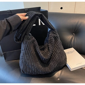 Close-up of black corduroy tote bag showing high-quality rib texture and soft fabric