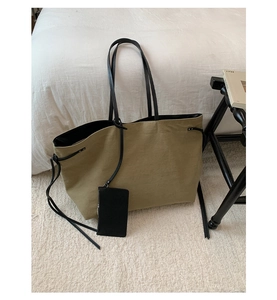 Vista dettagliata della borsa tote in tela con manici in pelle e pochette rimovibile