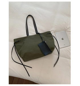 Dettagli della borsa tote in tela oliva con astuccio in pelle e tracolle lunghe