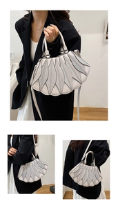 Detail der cremefarbenen Handtasche mit Blattnaht, Schultergurt und Muschelrandkante