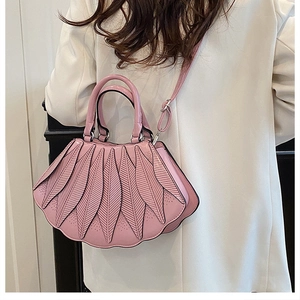 Rosafarbene Designer-Handtasche in Blattform, als Umhängetasche zum Blazer getragen