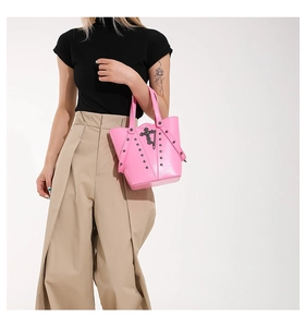 Detail of pink punk bucket bag with black metal cross chain and silver rivet studs