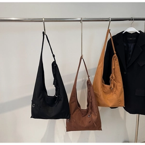 Hanging suede tote bags in black, brown and tan with knot shoulder strap details