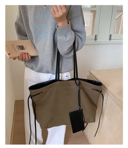 Close-up of minimalist large canvas tote bag with drawstring detail and small coin purse