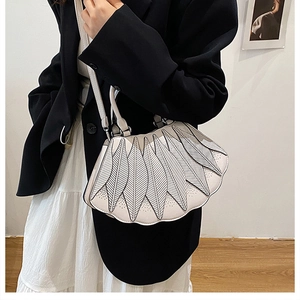 Detail der cremefarbenen Lederhandtasche mit Kontrastnähten und Lagen-Design