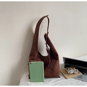 Detail of dark brown suede tote bag showing side drawstring knot and large capacity