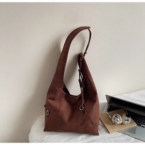 Macro shot of dark brown suede Hobo bag with minimalist tie detail and silver hardware buckle