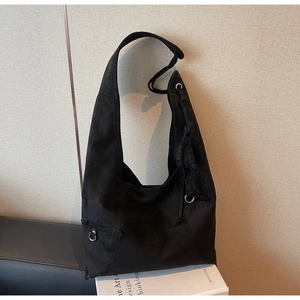 Detailed macro view of black suede texture on large tote bag with metallic buckle detail