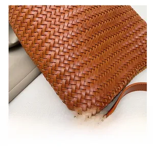 Macro shot of premium brown hand-woven leather bucket bag showing intricate craftsmanship