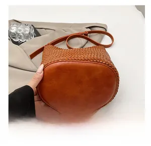 Macro shot of wear-resistant thick base on woven caramel bucket shoulder bag