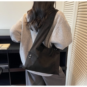 Detail of the minimalist black canvas tote bag with metal D-ring and adjustable strap