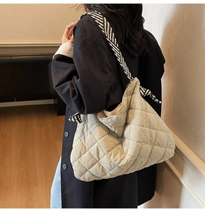 Detailed view of beige quilted tote bag with zebra print scarf detail on the shoulder strap