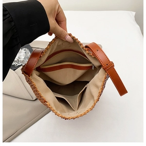 Detail view of woven shoulder bag interior with zipper pocket and lining