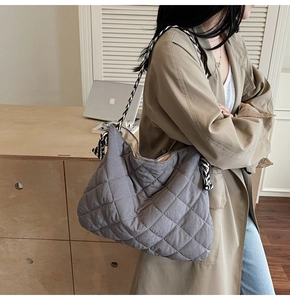 Close-up of a quilted tote bag with geometric patterns and a woven shoulder strap