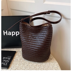 Detailed view of dark brown hand-woven bucket bag with wide texture and cream lining