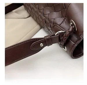 Close-up of premium silver hardware and dark brown woven leather texture on a handbag
