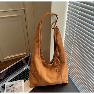 Detailansicht der braunen Wildledertasche mit dekorativem Kordelzug und D-Ring aus Metall