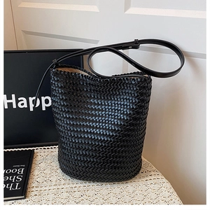 Detail of the high-quality hand-woven black bucket bag on a vintage lace tablecloth