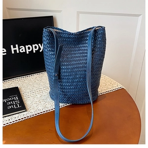 Detailed close-up of blue hand-woven bucket bag featuring a checkerboard texture pattern