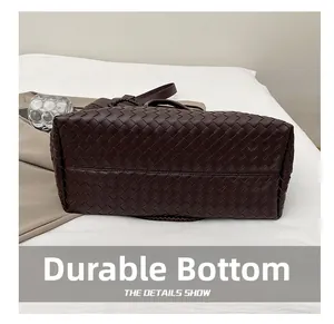 Macro detail of the durable wear-resistant bottom on this dark brown woven leather handbag