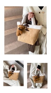 Detail of khaki suede bucket bag with white faux fur trim and bear charm