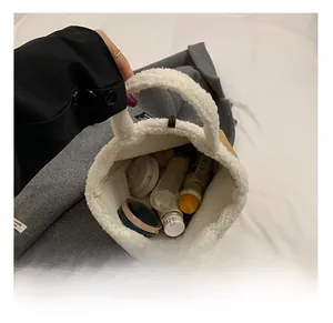 Detail showing spacious interior of white faux shearling bucket bag with cosmetics