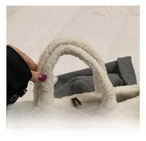 Detail showing the soft white plush faux fur handle and brown fabric of the bucket bag