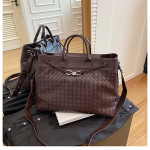 Detail of dark brown woven leather tote bag with sturdy handles and adjustable strap