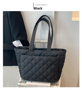 Detailed close-up of a black quilted tote bag with diamond stitching and wide straps