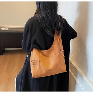 Brown suede hobo bag shown on model back view in a minimalist modern interior